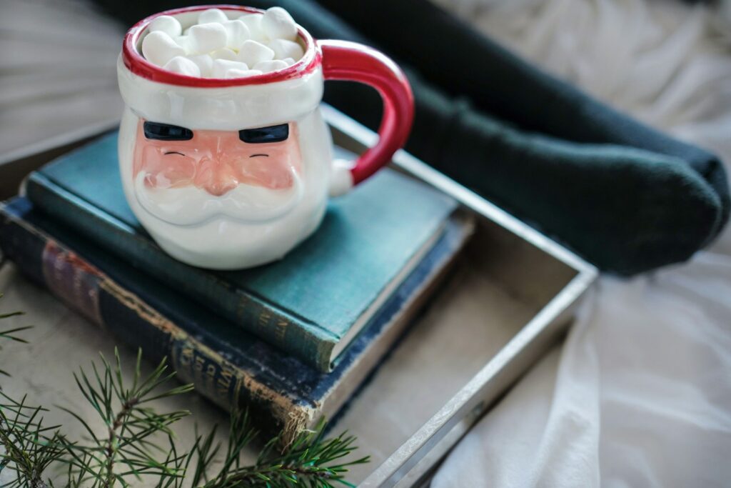 white and red ceramic Santa mug on books